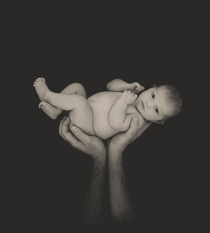 photo naissance bébé dans les mains noir et blanc